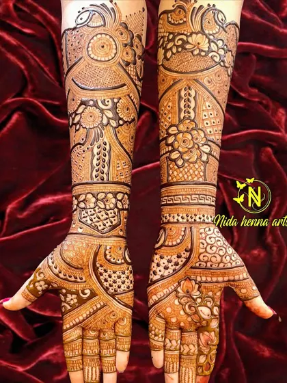 This Indian bridal design features a unique flow and structure. The patterns curve gracefully across the hands and arms, creating a dynamic and modern feel within a traditional framework.