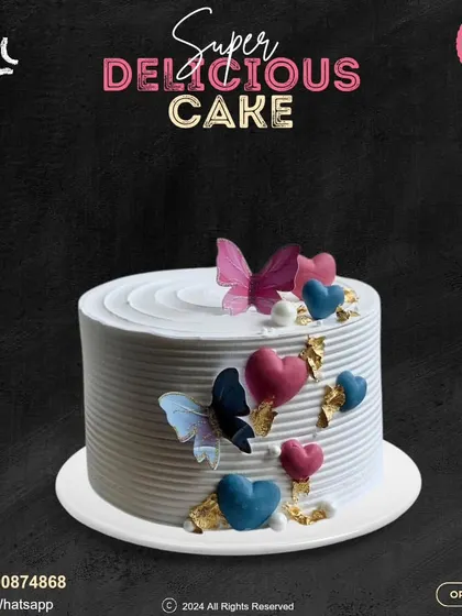 A beautiful cake adorned with colorful hearts and delicate butterflies. The clean, ribbed buttercream and touches of gold leaf add a layer of elegance to this whimsical design.