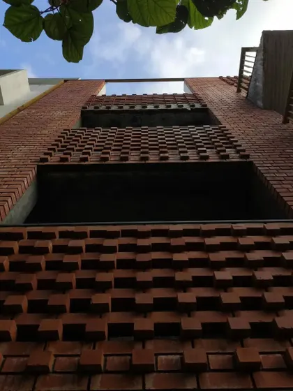 Looking up at the facade, this shot captures the layers of exposed brick and open balconies against the sky.
