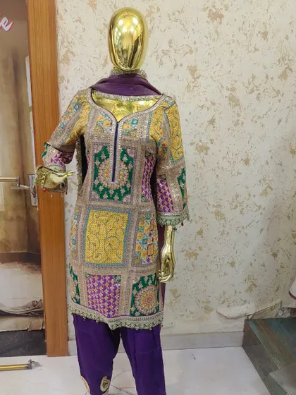Another view of the stunning multi-color embroidered suit on a mannequin, showcasing the intricate patchwork design from a different angle.
