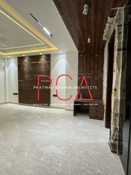 Another room in the Vasant Kunj residence, with dark wood paneling on the walls and ceiling, creating a cozy and sophisticated atmosphere.