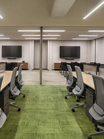 The same training rooms with partitions partially open, demonstrating the adaptability of the space. The design allows for seamless connection to the main work hall, fostering a culture of open communication.