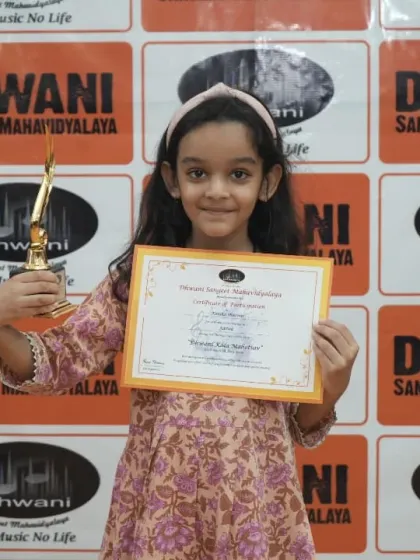A young student proudly displays her certificate and trophy.