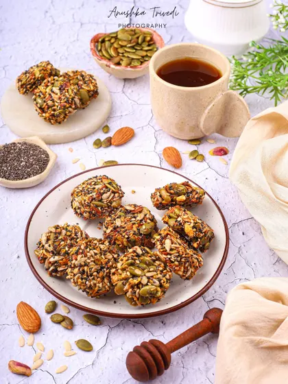 Healthy seed and nut bars, styled with a cup of tea for a wholesome and energizing snack idea.
