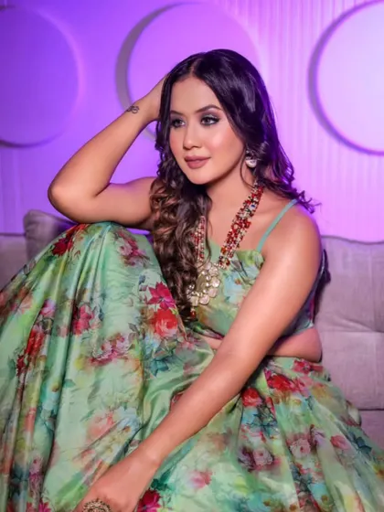 A relaxed pose in the green floral lehenga, showing its versatility and comfort. It's an easy-to-wear yet stylish option for any festive gathering.