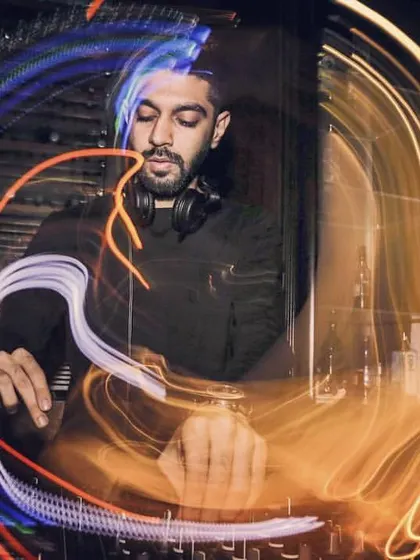 A long-exposure shot capturing the lights and energy around the DJ booth. This image visualizes the vibrant, electric atmosphere I create with my music.