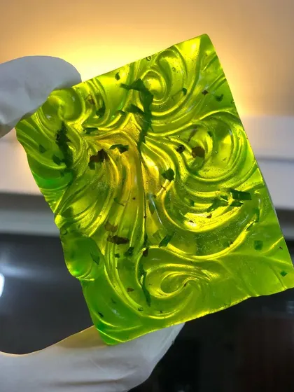 Another angle of the custom green 'Hydration Station' soap. The swirls and embedded herbs create a unique pattern in every bar, showcasing its handmade nature.