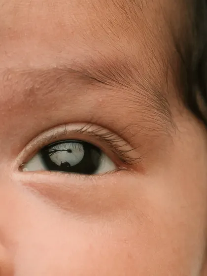A macro shot of a newborn's eye, reflecting the studio lights. It's a window into their brand new world.
