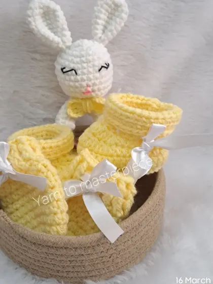 The yellow baby gift set presented in its basket, with the bunny rattle peeking out. It's a complete and thoughtful gift for a new arrival.