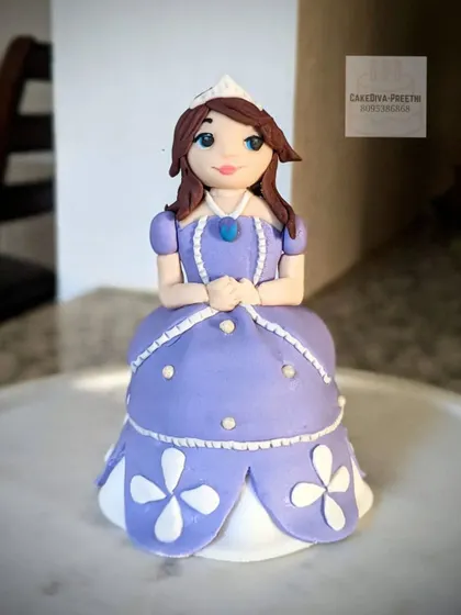 A handcrafted figurine of Princess Sofia, standing 6 inches tall. She is built with a combination of biscuits, cake, and rice crispies for structure, and then detailed with fondant. I was very happy with how her face turned out.