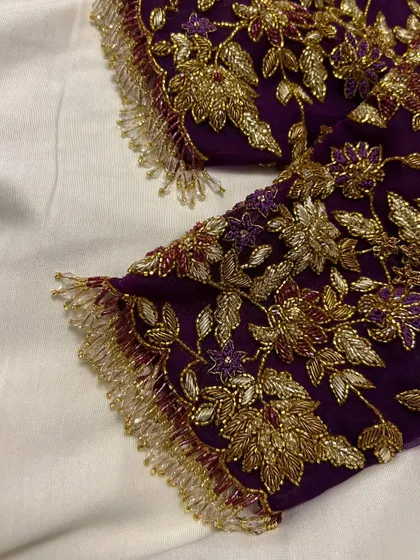 This purple net blouse was a joy to create for my dear client Sowmya's baby shower. The sheer sleeves are adorned with delicate, hand-embroidered floral vines in gold threadwork, creating a look of ethereal elegance for her special day.