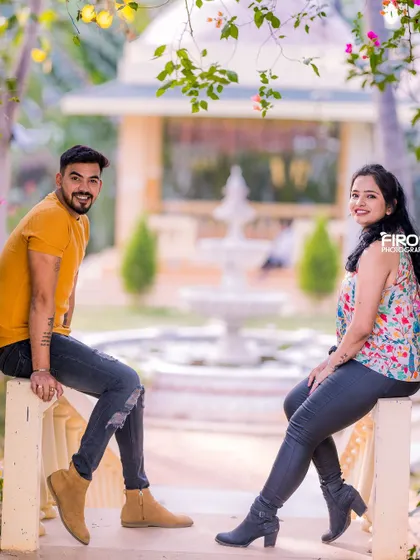 A relaxed and happy portrait of a couple on a balcony. Their casual outfits and the natural setting create a very authentic and down-to-earth feel.