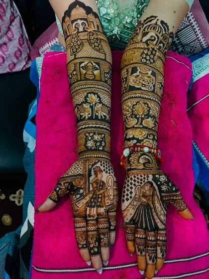 This full-arm design features dancing bride and groom figures on the palms, with traditional wedding procession elements like elephants and doli on the arms.