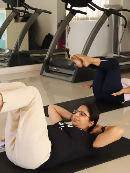 Students practicing the "hundred" exercise during a training session. The studio environment allows for focused learning and immediate feedback.