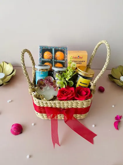 For a more rustic and eco-friendly touch, we offer hampers in sustainable Kauna grass baskets. This square basket is filled with treats like laddoo-shaped candles and healthy snacks, combining traditional charm with modern tastes.