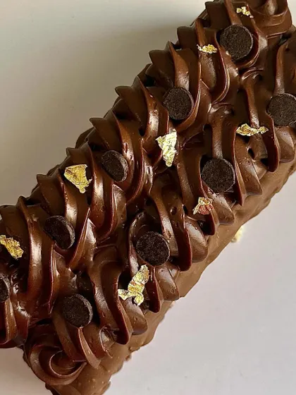 My Marble Cake is a beautiful blend of chocolate and vanilla, coated in a gourmet glaze. I finish it with chocolate ganache, chocolate callets, and a touch of gold leaf for an elegant look.
