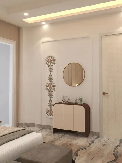 A small credenza and a round mirror are set against a wall with traditional Indian motif detailing, blending heritage with modern design.