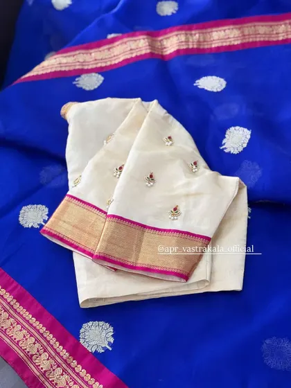 A similar off-white blouse paired with a royal blue saree.