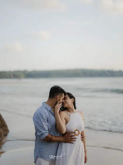 A tender and romantic moment, with the couple lost in each other's eyes against the backdrop of the sea.