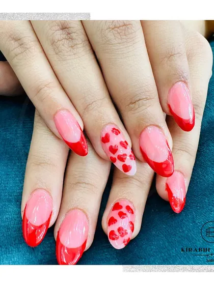 Another shot of the lovely red heart French manicure, highlighting the glossy finish and almond nail shape.