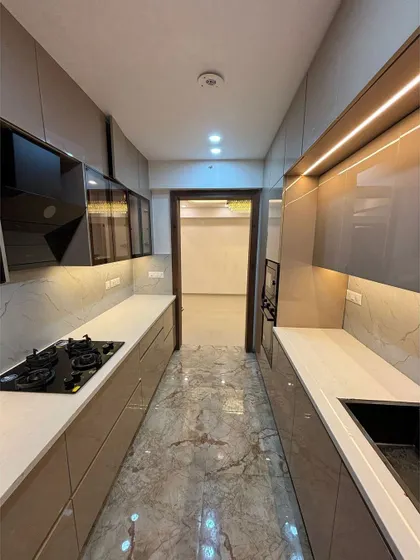 A view from the other end of the parallel kitchen, showing the sink area and upper cabinets. The design prioritizes a clean, continuous line for a very modern and organized look.