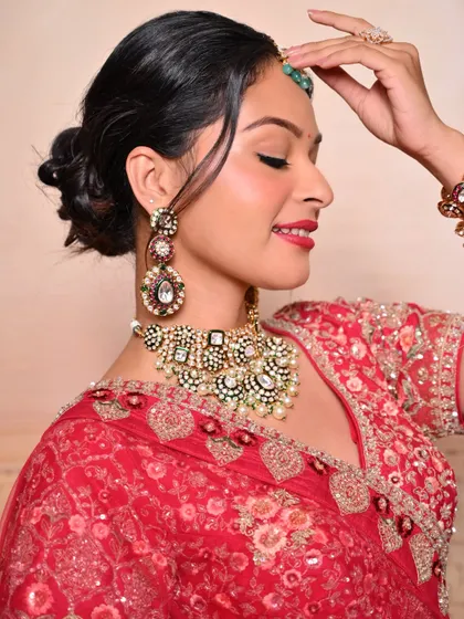A side profile showcasing the elegant bridal updo and the flawless blend of the makeup, perfect for a traditional wedding ceremony.