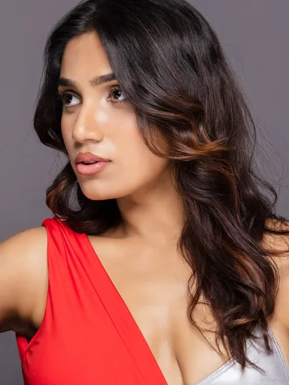 A beauty close-up of a model in a red and silver dress, with a soft and natural look.
