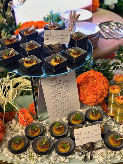 A tiered display of our Jackfruit Kulcha Ki Chaat appetizers at a festive event. The menu is elegantly displayed, showing guests the curated selection of dishes available.