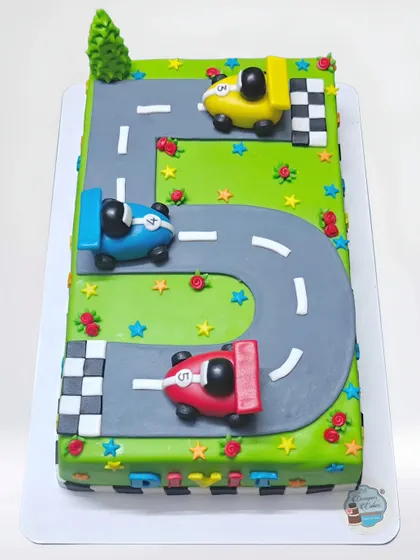 A car racing theme cake where the track forms the number 5. This rectangular cake is a fun and creative way to celebrate a 5th birthday for a little car enthusiast.
