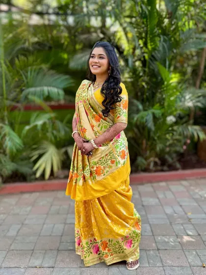 A full-length shot of the bride in her beautiful yellow saree for the Mahurat. The look is traditional, graceful, and full of sunshine.