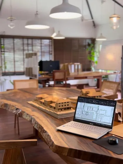 A view of our Goa studio, where ideas take shape. On the table, an architectural model sits next to a laptop with digital plans, showing how we blend traditional design methods with modern technology.