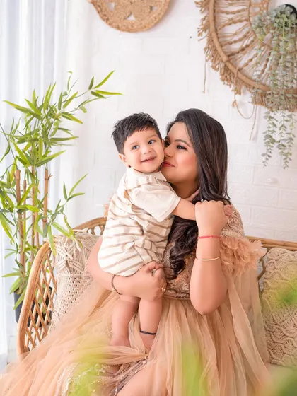 A mother's loving cuddle with her son. The warm, earthy tones of the setup and their outfits create a cozy and intimate feel.