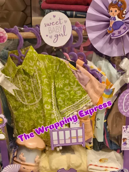 Another view of the purple-themed 'Sweet Baby Girl' hamper, showing the arrangement of clothes and decorative cutouts.