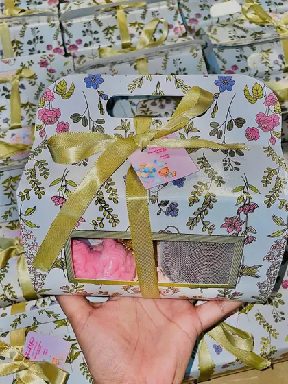 These floral baby shower return favors are elegant and sweet. The box includes a scented candle, baby-themed soaps, and a pack of chocolates.