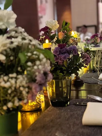 Another angle of our minimal table decor, featuring fresh flowers, candles in glass holders, and elegant place settings.