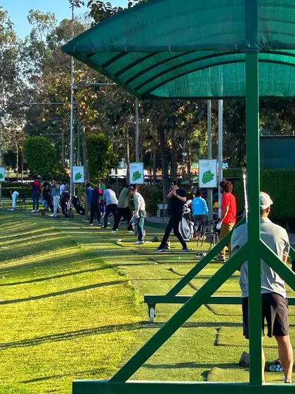 A view from behind a covered bay, showing the long line of golfers enjoying the range.