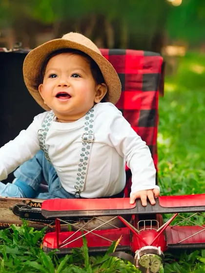 Ready for takeoff. This little aviator in a suitcase with his toy plane is a creative way to capture a milestone moment.