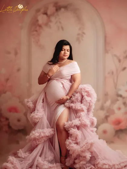 A quiet moment of reflection. The soft pink tones of the gown and the floral background come together to create a truly timeless and gentle portrait.