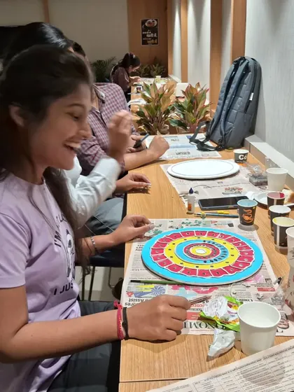 The joy of the process is just as important as the final product. This participant is smiling as she works on her colorful Lippan art, fully engaged in the creative moment.