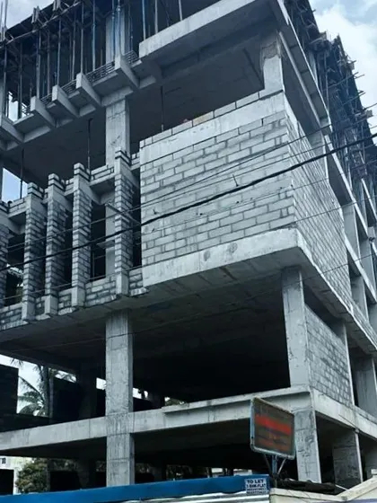 The concrete and blockwork structure of a commercial building on Hosa Road. This phase reveals the building's core form and the grid-like precision of its structural design.