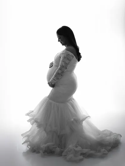 A classic black and white silhouette. This high-contrast, high-key technique beautifully outlines the shape of the mother and baby bump, creating a powerful and artistic image.