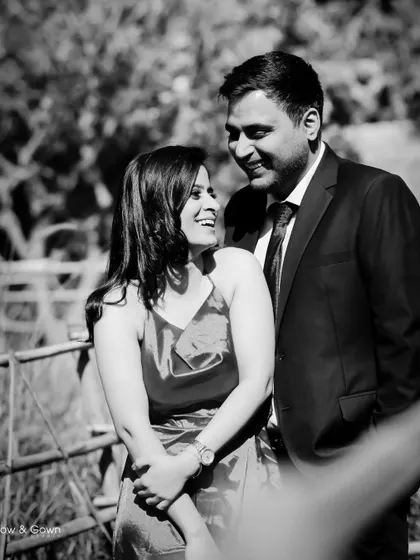A classic black and white portrait from a pre-wedding shoot. The natural outdoor setting and the couple's happy, relaxed expressions create a timeless and romantic image.