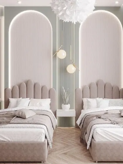 Arched, scalloped headboards with integrated backlighting are the standout feature in this beautiful shared room. The soft color palette and elegant wall molding create a space that feels both whimsical and chic.
