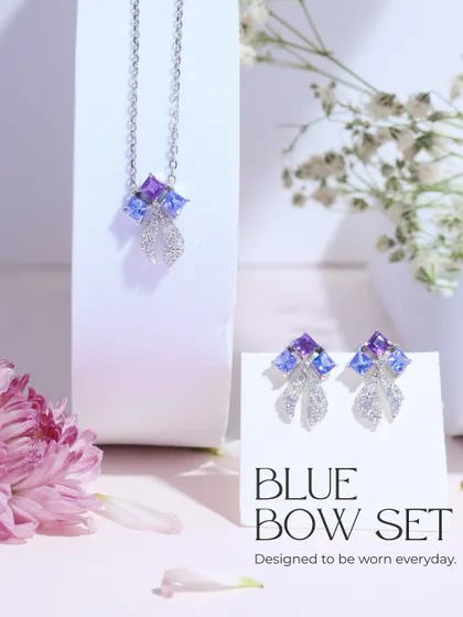 The complete Blue Bow Set, including the necklace and earrings. It's designed to be worn every day, adding a touch of cool-toned sparkle.