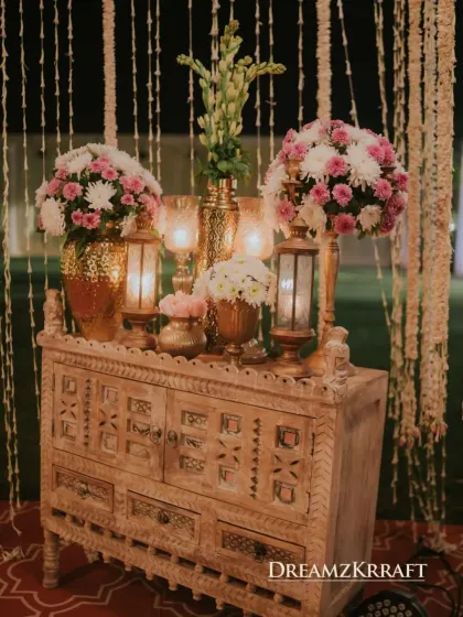 A rustic yet elegant console table decorated with florals and lanterns. We use unique furniture pieces to add character and create charming vignettes throughout the event space.