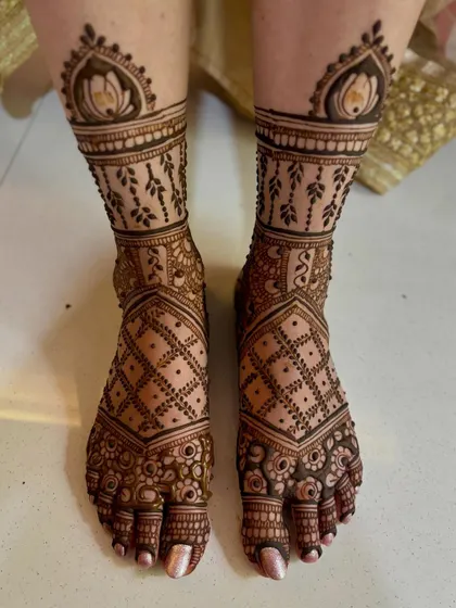 An intricate bridal feet design featuring lotus toppers, vine patterns, and a detailed grid work.