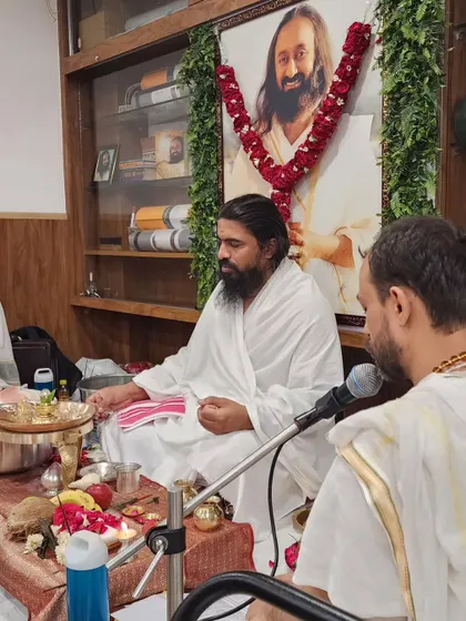The priest leading the Rudra Puja, with a portrait of Sri Sri Ravi Shankar in the background, whose teachings inspire our studio.