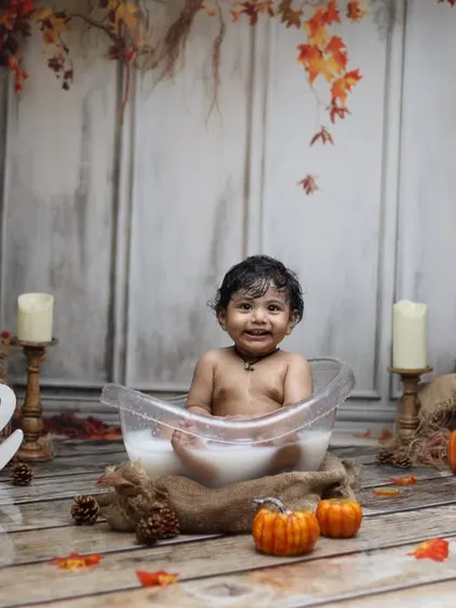 We create seasonal themes for our bathtub shoots, like this cozy autumn milk bath. Complete with pumpkins, fall leaves, and a 'One' sign, it's a perfect way to celebrate a first birthday.