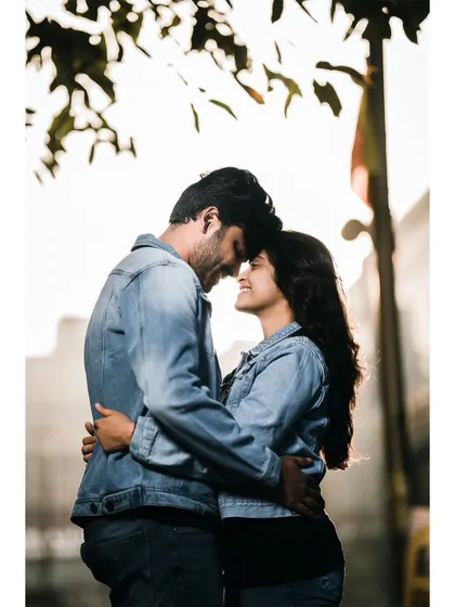 An intimate, backlit portrait of a couple, their faces close together, creating a beautiful silhouette against the morning light.