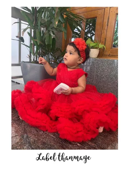 Another photo from the first birthday shoot, with the baby girl in her red frilled frock.